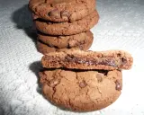 Gros plan sur une pile de biscuits au chocolat, dont un est coupé en deux révélant un cœur coulant de Nutella. Une recette de biscuit Nutella parfaite pour les gourmands.