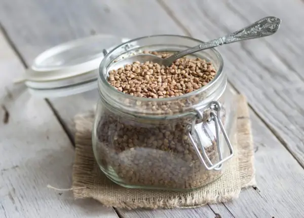 Un bocal en verre rempli de sarrasin, prêt à être cuisiné. C'est quoi le sarrasin ? Une graine nutritive et polyvalente.