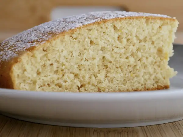 Tranche de gâteau moelleux saupoudrée de sucre glace, préparée avec de la farine ig bas pour un plaisir léger.